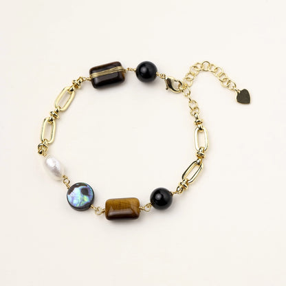 Gold-plated chain bracelet featuring tiger's eye, obsidian, freshwater pearls and abalone shell on white background