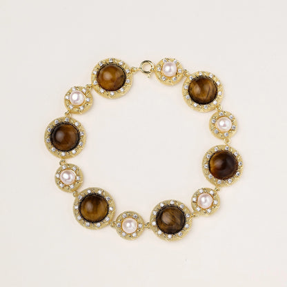 Ornate gold-plated bracelet with alternating brown tiger's eye stones and white freshwater pearls in crystal-accented settings