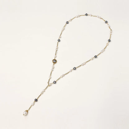 Long gold-plated necklace with alternating white and gray freshwater pearls spaced along delicate chain segments