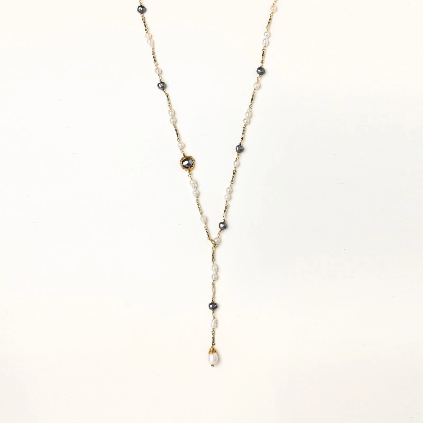 Long gold-plated necklace with alternating white and gray freshwater pearls spaced along delicate chain segments