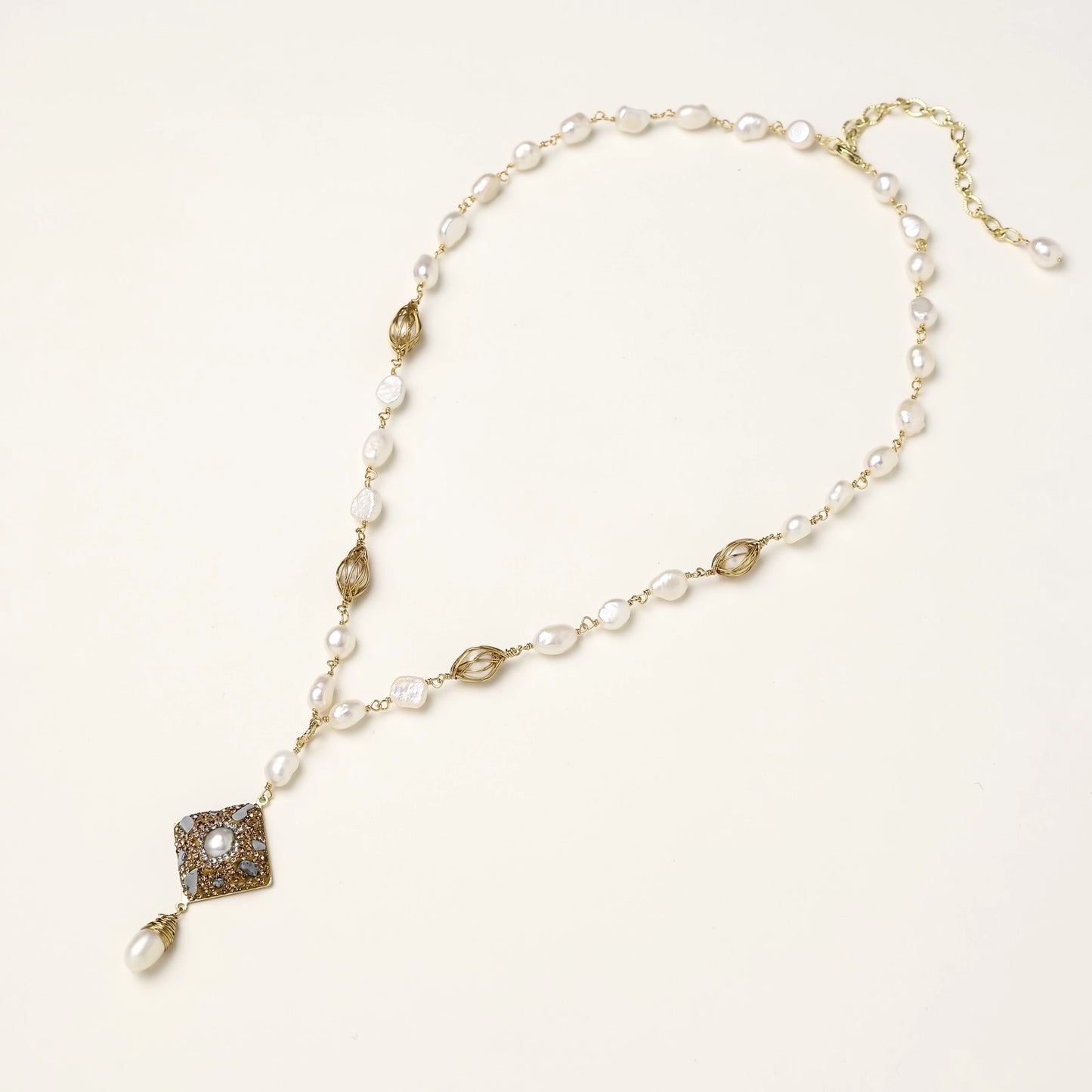 Elegant 14K gold plated necklace with freshwater pearls and ornate crystal diamond pendant on cream background.