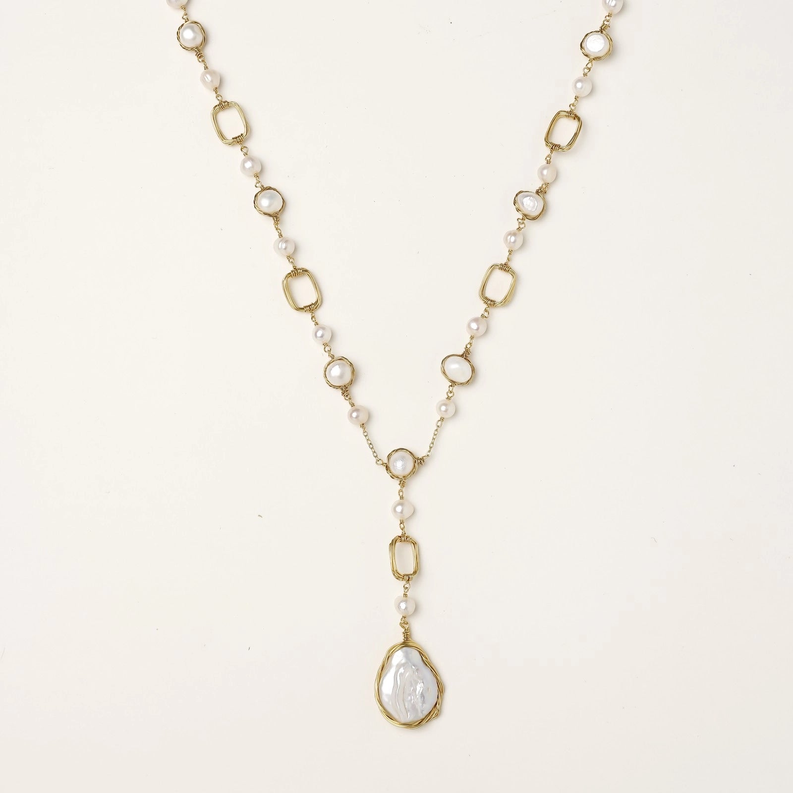 Y-shaped gold-plated necklace with freshwater pearls and geometric elements, featuring a baroque pearl pendant drop