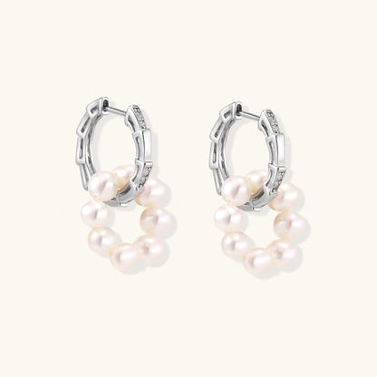 Sterling silver huggie hoop earrings with clustered white freshwater pearls and crystal accents on white background.