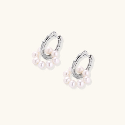 Sterling silver huggie hoop earrings with clustered white freshwater pearls and crystal accents on white background.