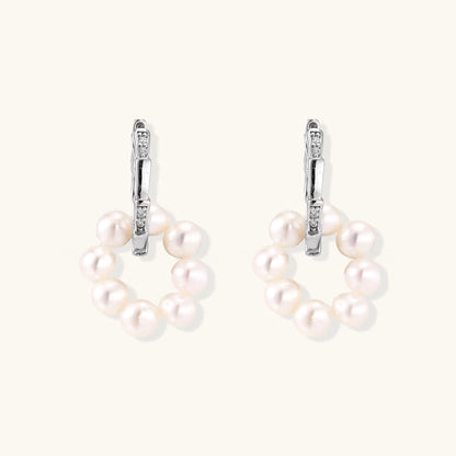 Sterling silver huggie hoop earrings with clustered white freshwater pearls and crystal accents on white background.