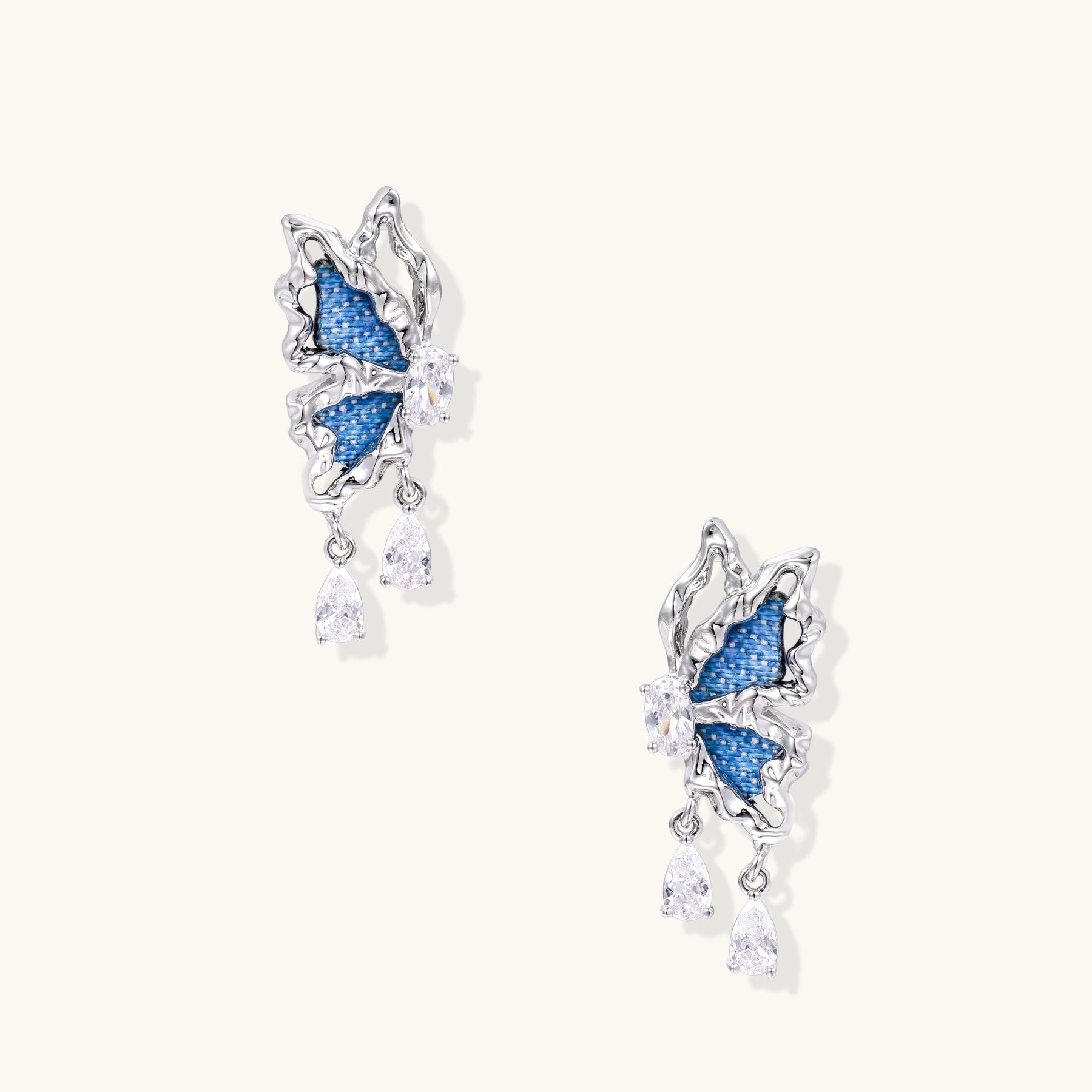 Gold-plated brass earrings featuring blue denim fabric insets and sparkling zirconia crystals with teardrop dangles