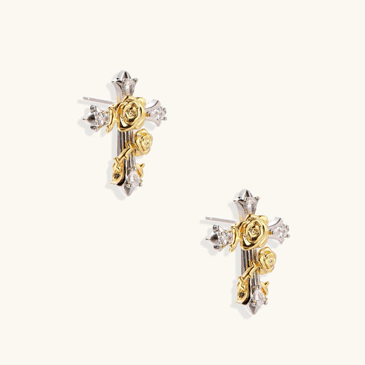 Two-tone cross earrings with gold roses and silver base featuring crystal accents on beige background.