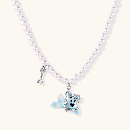 Pearl necklace with adorable blue dog pendant featuring crystal accents and bone charm on neutral background