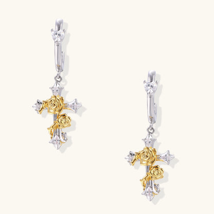 Ornate cross-shaped dangle earrings with gold roses and sparkling zirconia stars on silver-toned base with hoop closures.