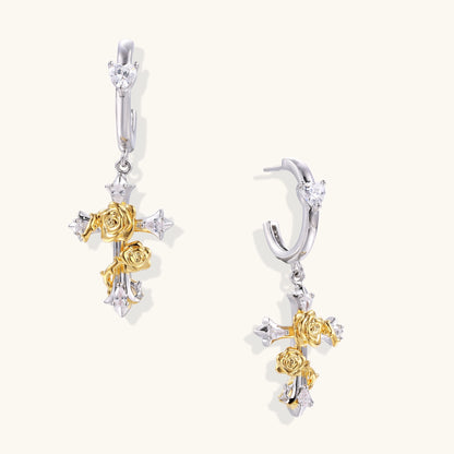 Ornate cross-shaped dangle earrings with gold roses and sparkling zirconia stars on silver-toned base with hoop closures.