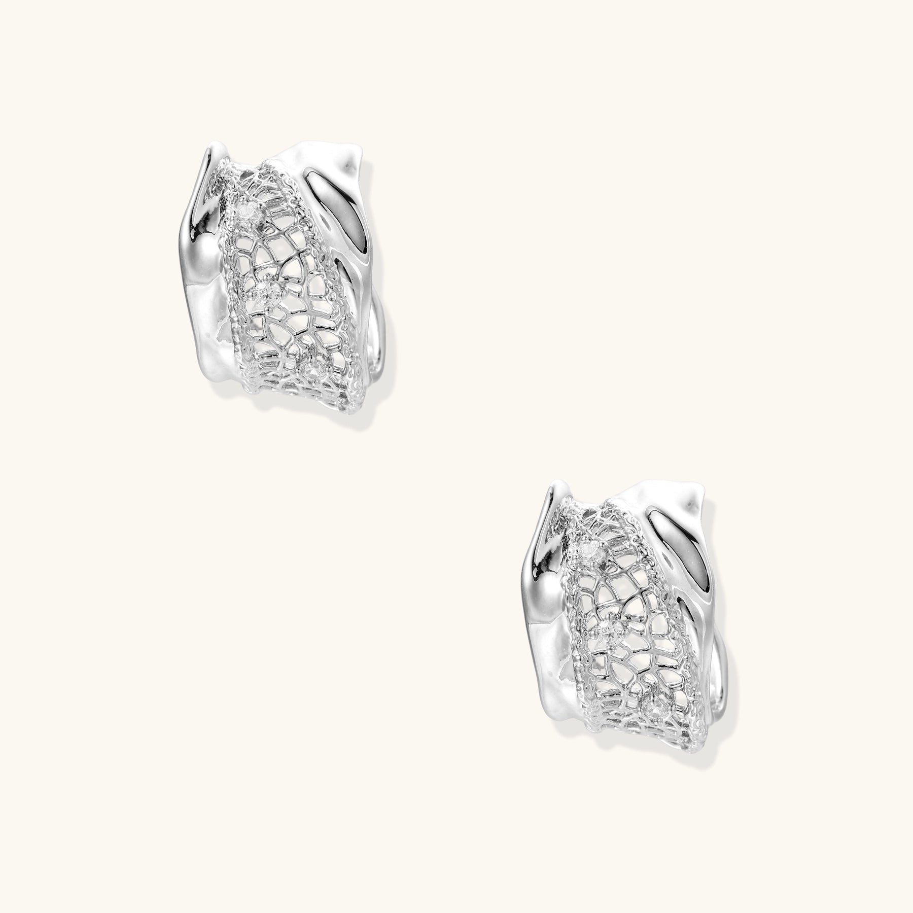 Small gold-plated brass hoop earrings with geometric lattice pattern and zirconia accents on white background.