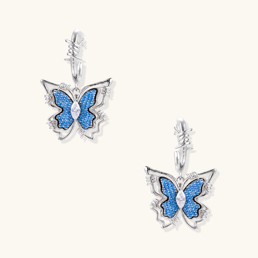 Pair of gold-plated hoop earrings featuring butterfly charms with blue textured wings and clear zirconia accents