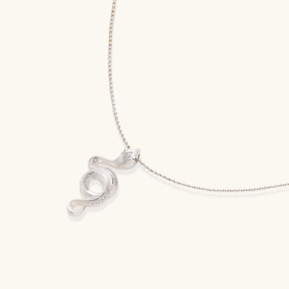 Sterling silver snake pendant necklace with zirconia crystals on adjustable chain against cream background