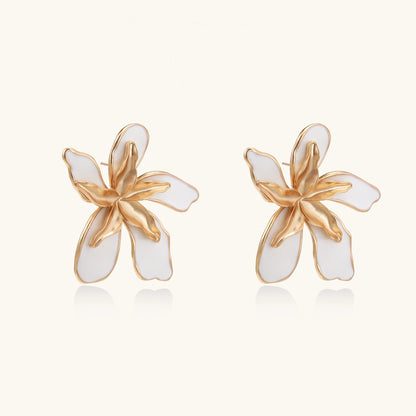 Large floral stud earrings with gold-plated brass petals and white enamel centers on neutral background
