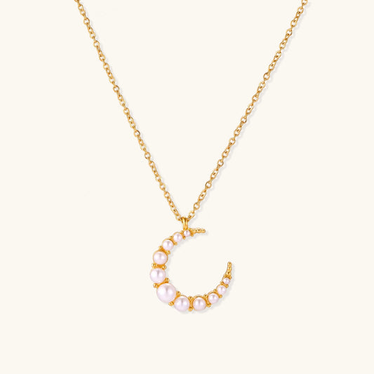 Delicate 18K gold plated necklace featuring crescent moon pendant with white shell pearl beads on neutral background.