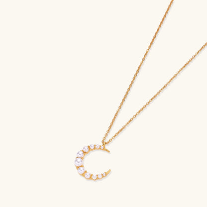 Delicate 18K gold plated necklace featuring crescent moon pendant with white shell pearl beads on neutral background.