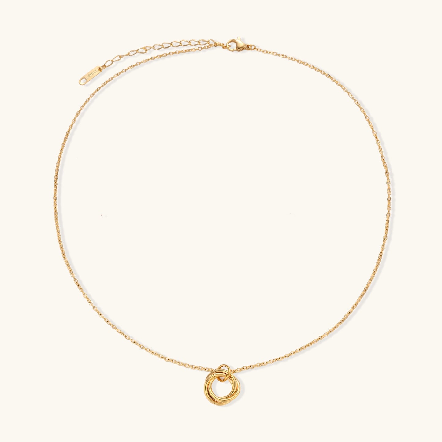 Close-up of a gold-plated stainless steel necklace with interlocking twisted ring pendant on white background