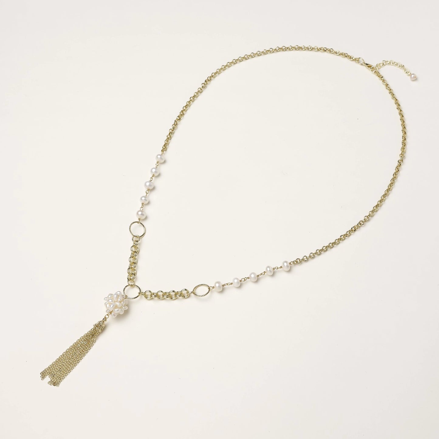 Long gold-plated necklace with freshwater pearls, chunky chain links, and flowing tassel pendant