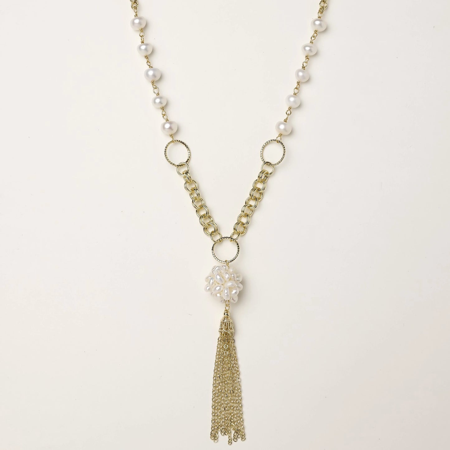 Long gold-plated necklace with freshwater pearls, chunky chain links, and flowing tassel pendant