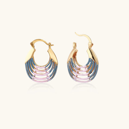 Gold hoop earrings with gradient blue-to-pink enamel in ribbed fan design on beige background