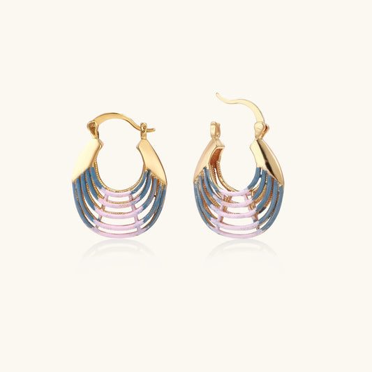 Gold hoop earrings with gradient blue-to-pink enamel in ribbed fan design on beige background