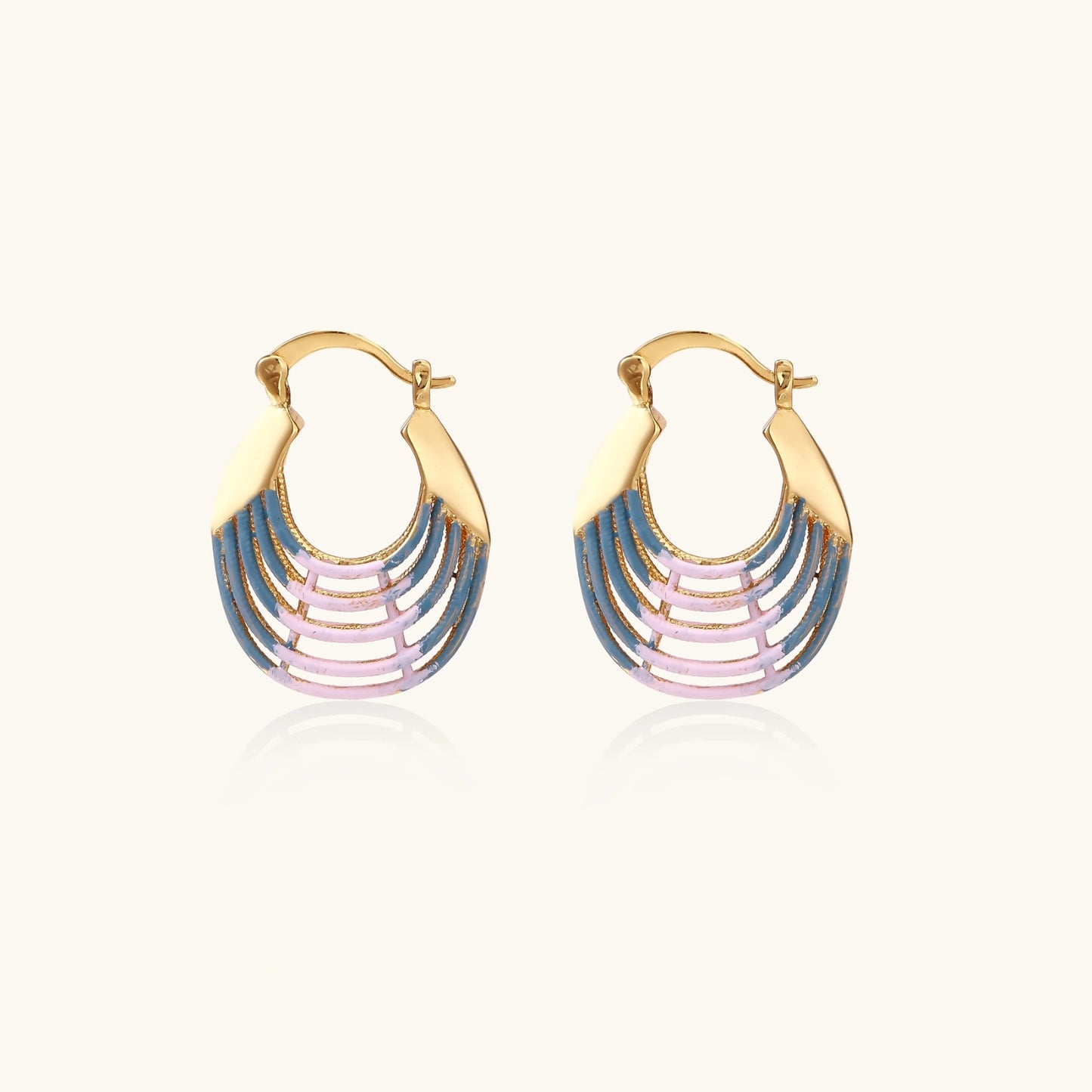 Gold hoop earrings with gradient blue-to-pink enamel in ribbed fan design on beige background