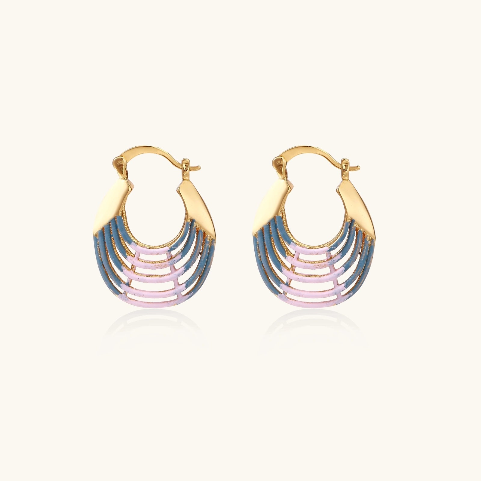 Gold hoop earrings with gradient blue-to-pink enamel in ribbed fan design on beige background