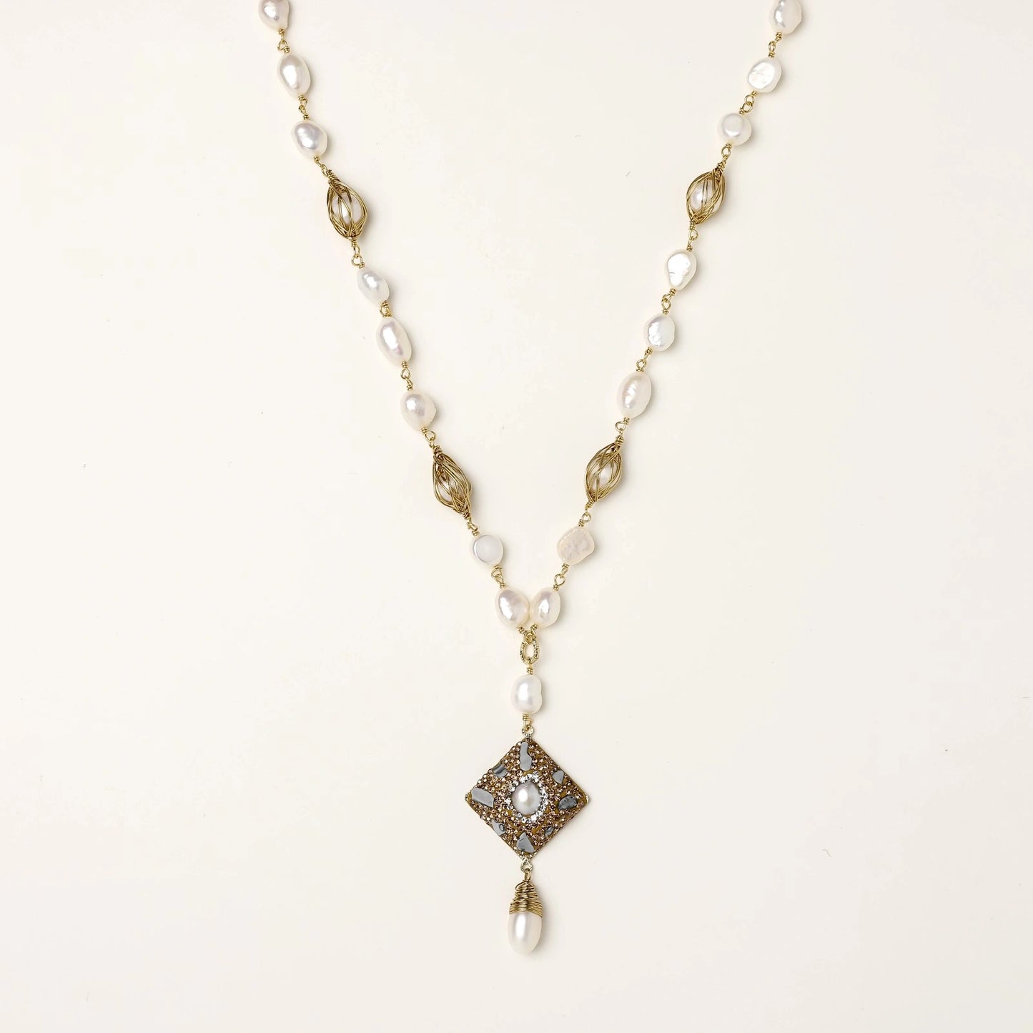 Y-shaped necklace with freshwater pearls, gold filigree stations, and ornate diamond-shaped centerpiece with pearl drop