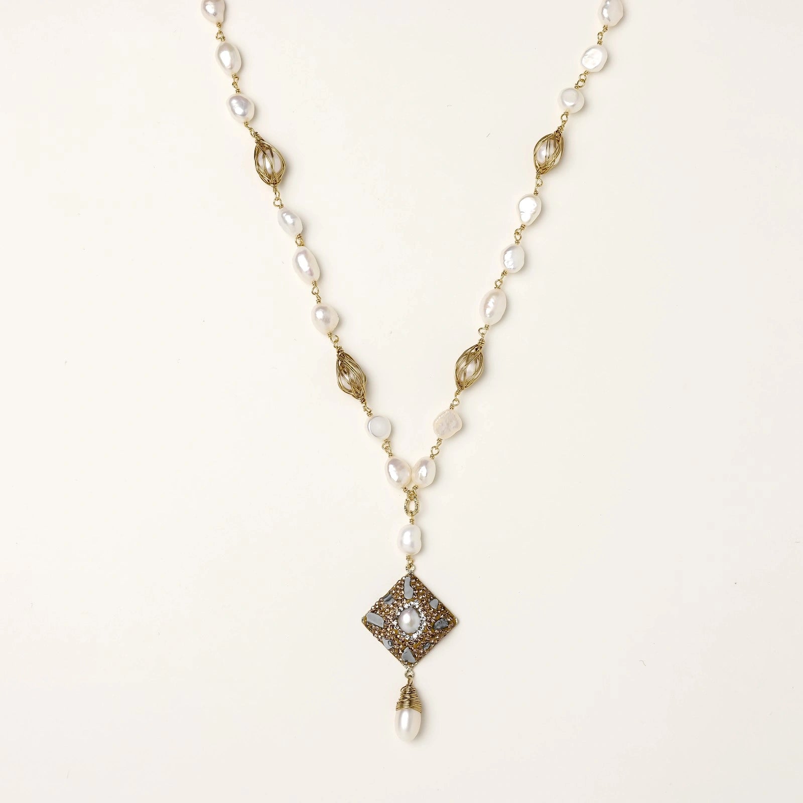 Y-shaped necklace with freshwater pearls, gold filigree stations, and ornate diamond-shaped centerpiece with pearl drop