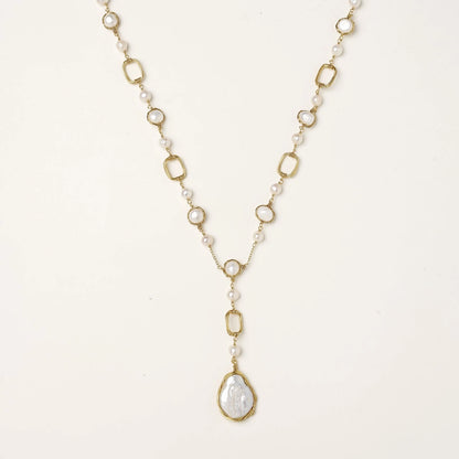 Long gold-plated necklace with alternating freshwater pearls and crystal bezels, featuring a large baroque pearl pendant