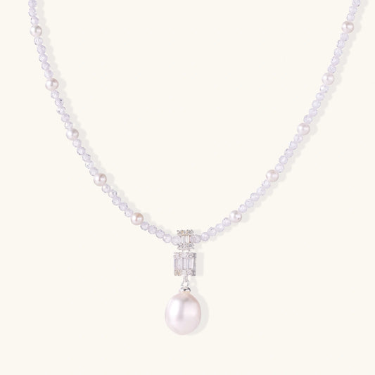 Dainty necklace with lavender crystal beads, freshwater pearls, geometric pendant, and large pearl drop on white background.