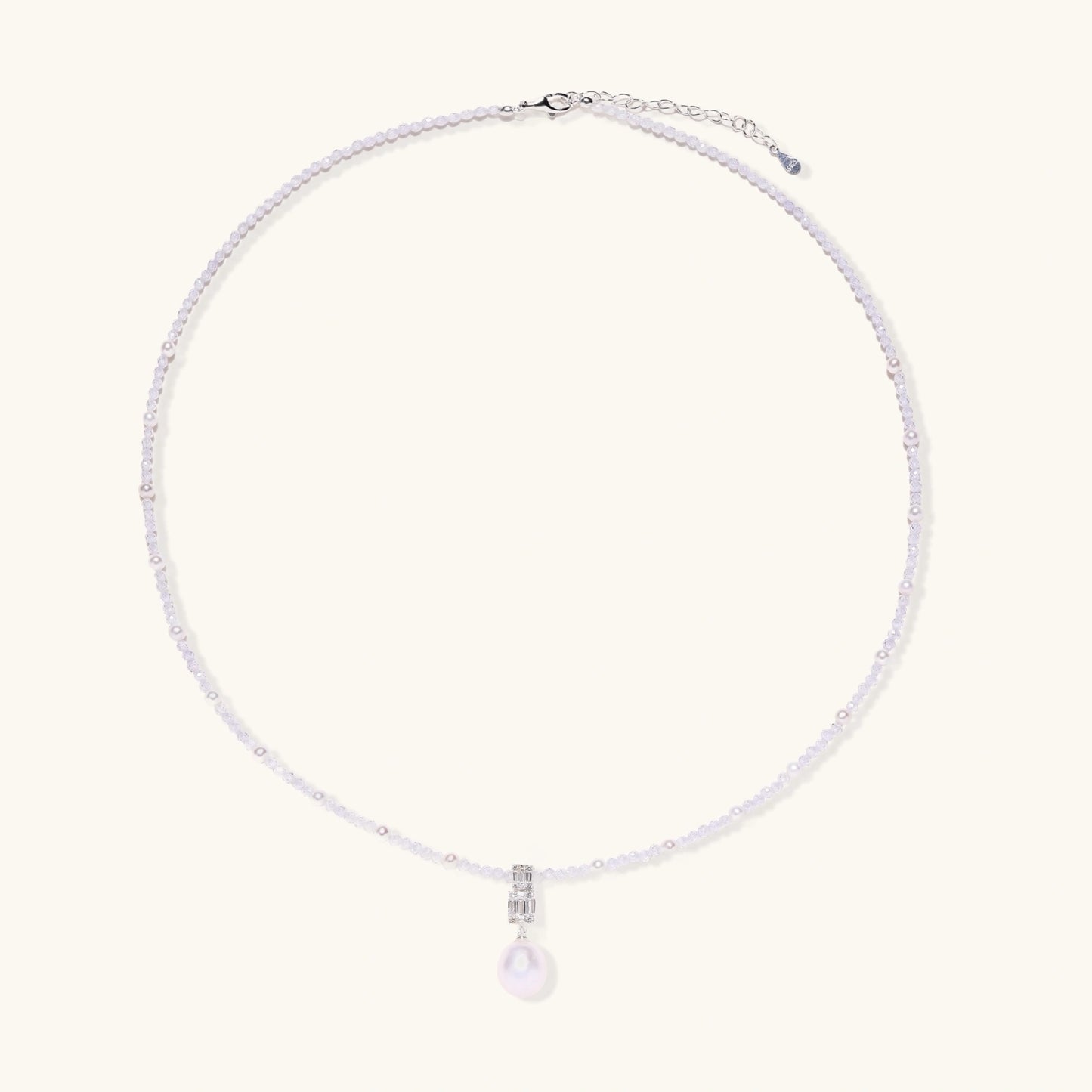 Dainty necklace with lavender crystal beads, freshwater pearls, geometric pendant, and large pearl drop on white background.