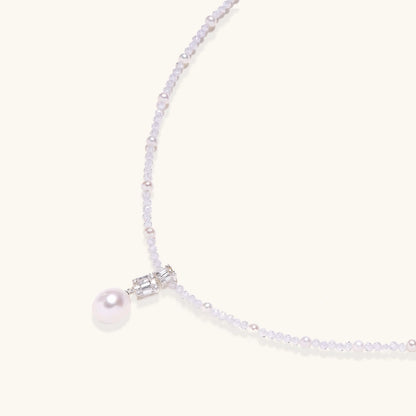 Dainty necklace with lavender crystal beads, freshwater pearls, geometric pendant, and large pearl drop on white background.