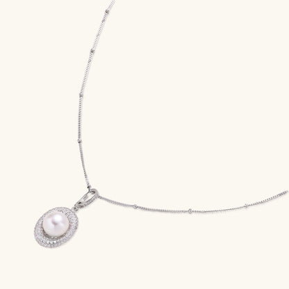 Oval sterling silver pendant with crystal halo surrounding a white freshwater pearl on delicate chain