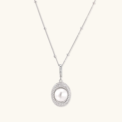 Oval sterling silver pendant with crystal halo surrounding a white freshwater pearl on delicate chain