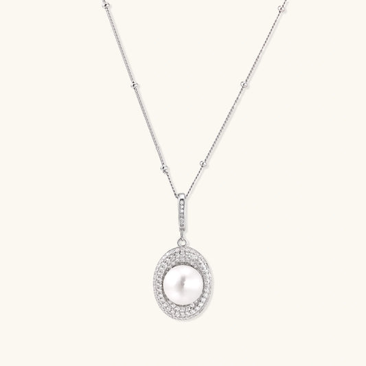 Oval sterling silver pendant with crystal halo surrounding a white freshwater pearl on delicate chain