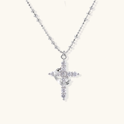 White gold-plated cross pendant adorned with sparkling zirconia stones and crescent moon accent on ball chain