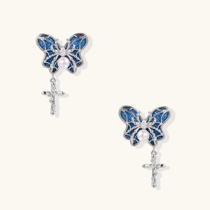 Royal blue denim butterfly earrings with white pearl centers and silver cross charms on white background
