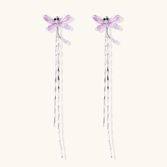 Long drop earrings with translucent lavender enamel dragonfly wings and white gold plated segmented bodies on white background