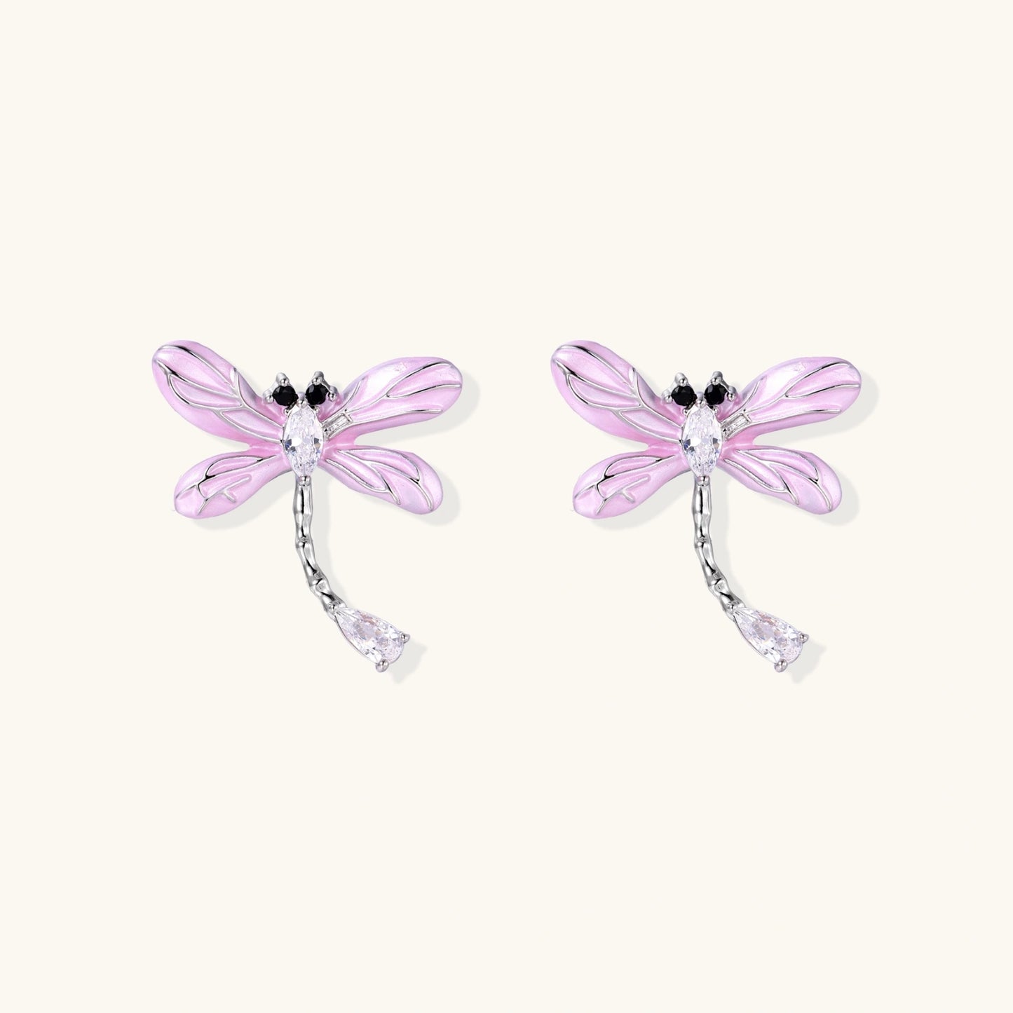 Long drop earrings with translucent lavender enamel dragonfly wings and white gold plated segmented bodies on white background