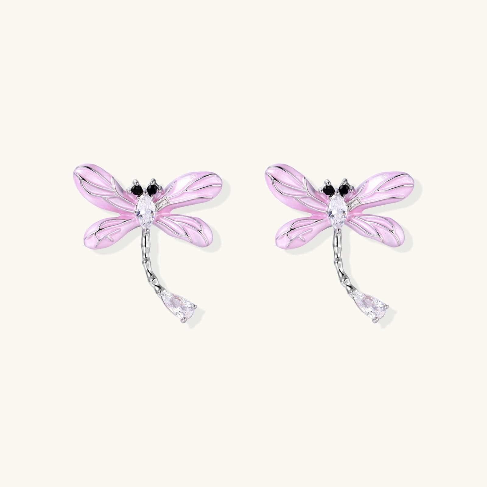 Long drop earrings with translucent lavender enamel dragonfly wings and white gold plated segmented bodies on white background