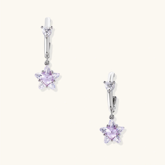 White gold plated huggie earrings with clear CZ accents and dangling lavender star-shaped crystals on cream background