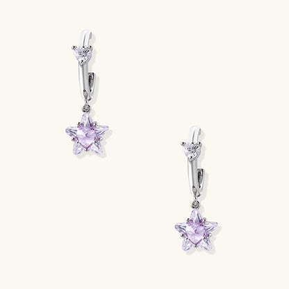 White gold plated huggie earrings with clear CZ accents and dangling lavender star-shaped crystals on cream background