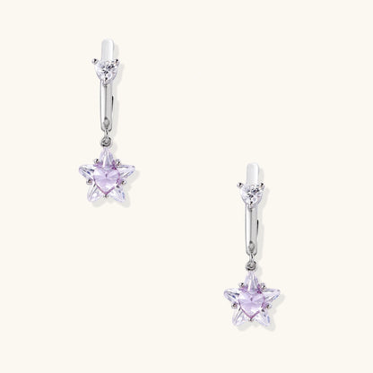 White gold plated huggie earrings with clear CZ accents and dangling lavender star-shaped crystals on cream background