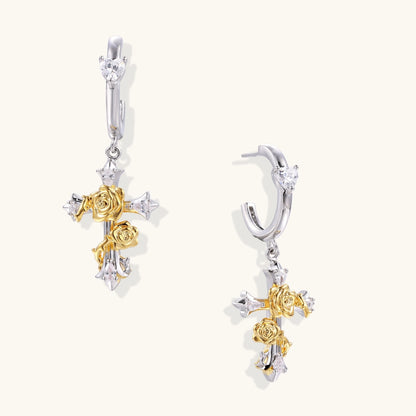 Ornate gold plated cross drop earrings with rose details and sparkling zirconia stones on white background.