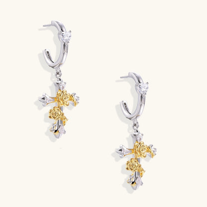 Ornate gold plated cross drop earrings with rose details and sparkling zirconia stones on white background.