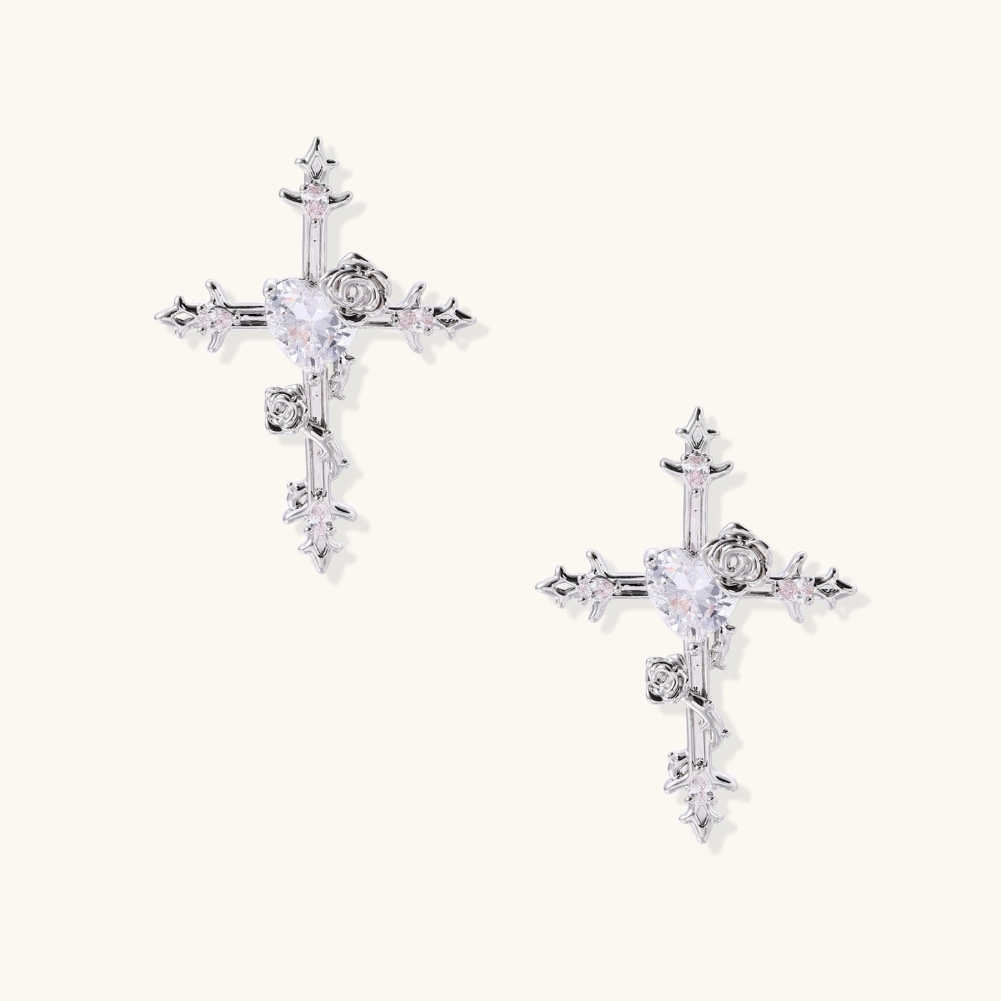 Ornate gold plated cross drop earrings with rose details and sparkling zirconia stones on white background.