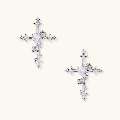 Ornate gold plated cross drop earrings with rose details and sparkling zirconia stones on white background.