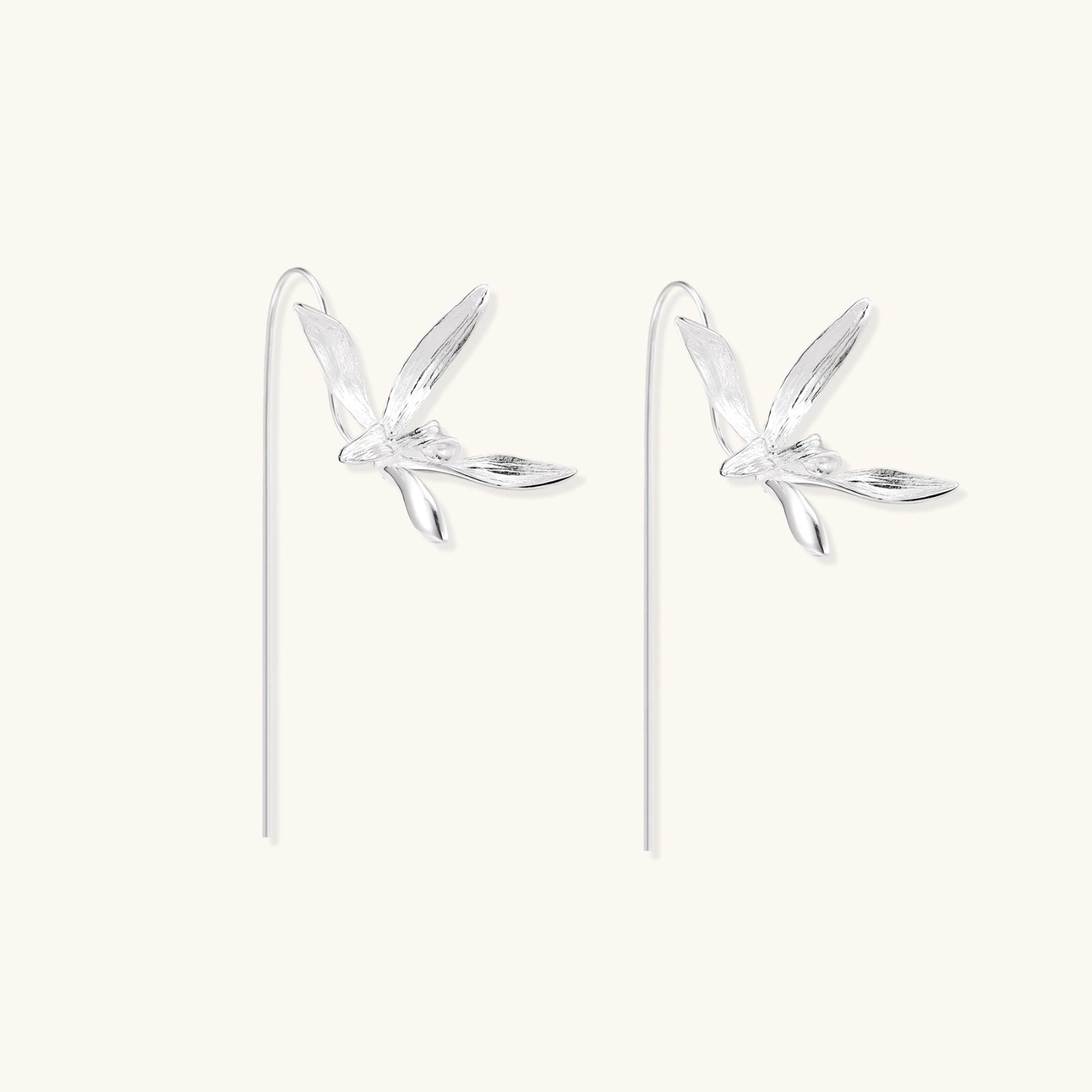 Delicate sterling silver dragonfly earrings with textured wings and curved threader hooks on white background