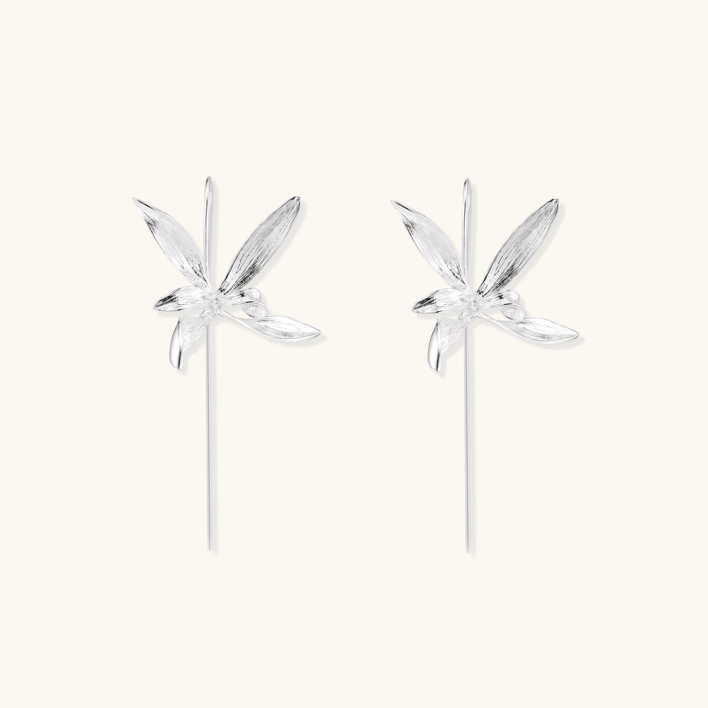 Delicate sterling silver dragonfly earrings with textured wings and curved threader hooks on white background